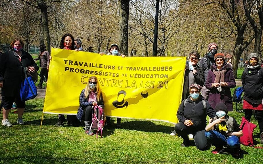 Des membres du collectif TTPE avec une bannière contre la loi 21, le 1er mai 2021.